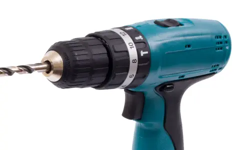 Taladro percutor inalámbrico de color turquesa con broca metálica. El simbolo taladro percutor se ve en su selector de torque.