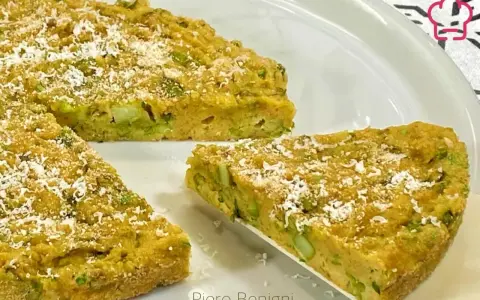 Una fetta di torta salata asparagi, dorata e cosparsa di parmigiano, pronta per essere gustata.