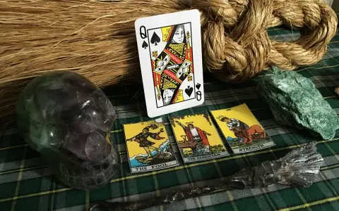 Wróżenie z kart inaczej: kryształowa czaszka, talie kart, miotła i magiczna różdżka tworzą mistyczną atmosferę.