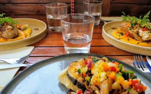 Trois assiettes de poisson grillé, purée de courge, légumes croquants et herbes fraîches. Une spécialité pyrénéenne à déguster.