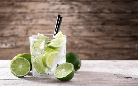 Orzeźwiający drink z limonką i lodem, ozdobiony plasterkami cytrusów. Idealny na upalne dni.