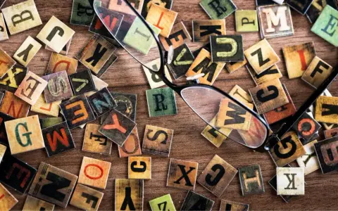 Un occhio attento scruta le lettere sparse, una figura retorica che unisce due termini contraddittori, creando un caos ordinato di parole.