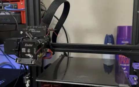 Głowica drukująca klipper ender 3 z kablem w oplocie. Na półce w tle fioletowa puszka z napisem "aussie".
