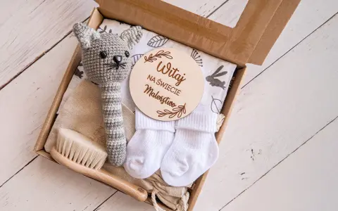 Zestaw na baby shower: szydełkowy kotek, skarpetki, szczotka i tabliczka "Witaj na świecie Maleństwo". Idealny pomysł, ile dać na baby shower.