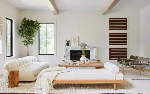 Salones blancos y madera: un sofá blanco texturizado, un diván de madera y un árbol interior crean un espacio acogedor.