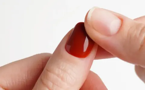 Dettaglio di un'unghia con smalto gel rosso intenso, perfetta per un tutorial unghie gel principianti.
