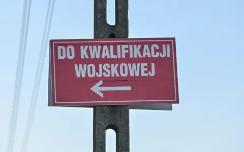 Czerwony znak z białym napisem "DO KWALIFIKACJI WOJSKOWEJ" i strzałką w lewo. Kategoria: d wojsko.