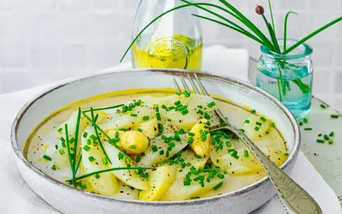 Ein Teller mit Spargel Salat, garniert mit Schnittlauch und einer leichten Sauce.