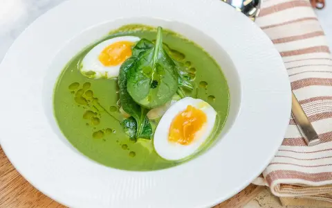 En krämig spenatsoppa med halverat kokt ägg och färsk spenat. Ett enkelt och gott spenatsoppa recept.