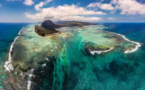 Niesamowity widok na Mauritius, gdzie podwodny wodospad tworzy iluzję spływającego piasku i mułu do głębin oceanu.