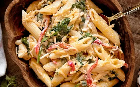 Penne w kremowym sosie z dodatkiem szpinaku i papryki. Ta tradycyjna sałatka z makaronem wygląda pysznie!
