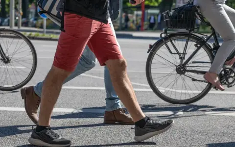 Ludzie idą i jadą na rowerze po mieście. Czy jazda na rowerze odchudza brzuch? Aktywność fizyczna pomaga spalać kalorie.