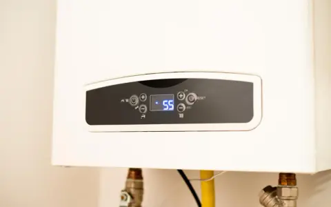 Panel de control de un calentador de gas butano, mostrando la temperatura actual de 55 grados.