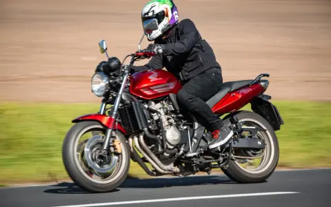 Motocyklista w kasku w stylu Jokera pędzi na czerwonym Honda CBF 600. Dane techniczne tego modelu są imponujące.