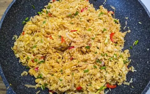 Pyszny ryż smażony z jajkiem, doprawiony papryczką chili i szczypiorkiem, gotowy do podania.