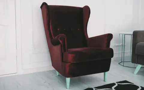 Elegancki, bordowy fotel z aksamitu. Zastanawiasz się, czym wyczyścić fotel z materiału, by wyglądał jak nowy?