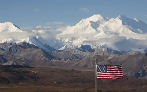 US-Flagge vor schneebedeckten Bergen des Denali Nationalparks.