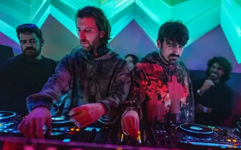 Los agentes del tiempo, DJs concentrados, manipulan las consolas bajo luces de neón, creando ritmos que desafían el tiempo.