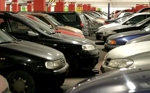 Rzędy samochodów na parkingu podziemnym. Widać oznaczenia B10, które mogą sugerować wymiary miejsca parkingowego.