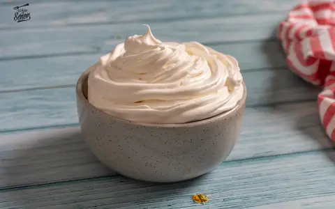 Nata montada perfecta en un cuenco gris, lista para decorar postres.