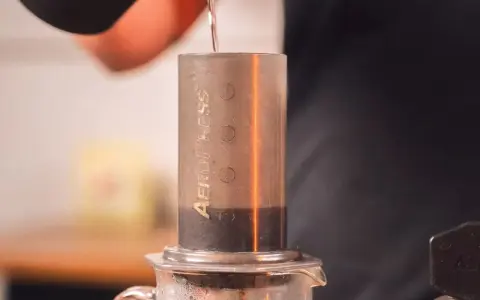 Przygotowanie kawy metodą aeropress cold brew. Woda powoli spływa do cylindra z kawą.