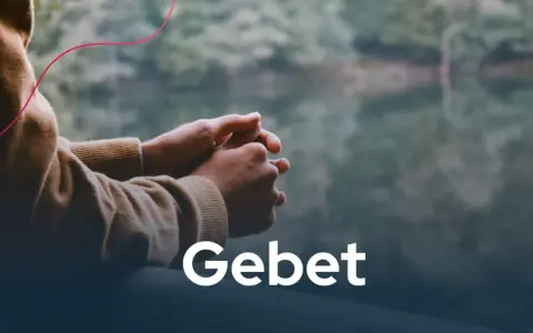 Hände im Gebet, die Ruhe und christliche Impulse in der Natur suchen. Das Wort "Gebet" steht im Vordergrund.
