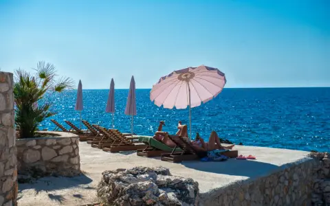 Słoneczna plaża w Czarnogórze, na co uważać? Leżaki, parasole i turkusowe morze. Idealne miejsce na relaks, ale pamiętaj o kremie z filtrem!
