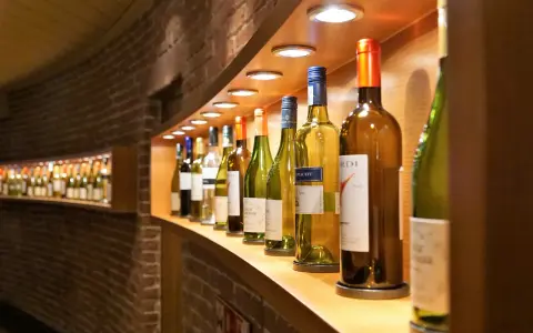 Eine Reihe von Wein- und Sektflaschen, einige davon sind bereits geöffnet. Die Frage, ob Rotwein schlecht werden kann, beschäftigt viele Weinliebhaber.