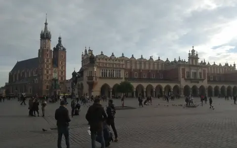 Spacer po Rynku Głównym, sercu historycznego centrum Krakowa. W tle Bazylika Mariacka i Sukiennice.
