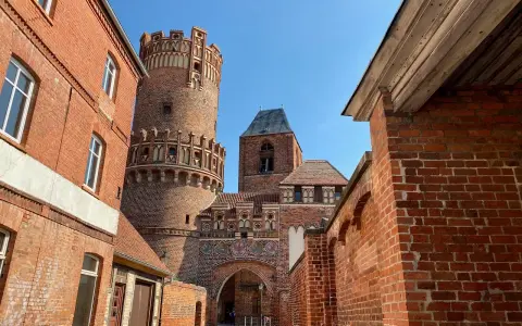 Historische Backsteinarchitektur mit einem runden Turm und Torbogen. Ein tolles Motiv für Ausflugsziele Sachsen-Anhalt.