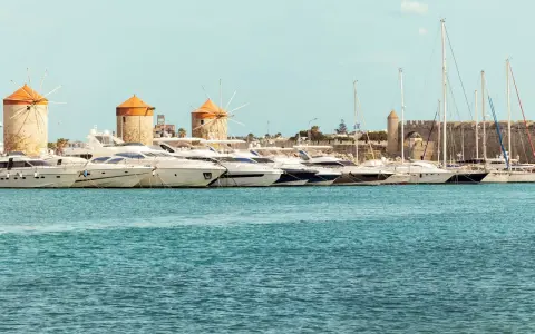 Väderkvarnar och lyxyachter i hamnen vid Rhodos stad. En historisk karta över Rhodos stad skulle visa denna vy.