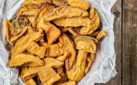 Un cesto pieno di croccanti funghi fritti, cosparsi di sale grosso, pronti per essere gustati.