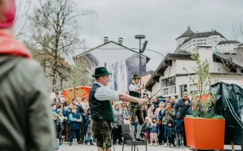 Wielkanoc w Austrii: mężczyźni w tradycyjnych strojach demonstrują umiejętności z batami przed tłumem widzów.