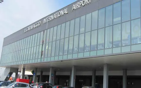 L'aeroporto Il Caravaggio di Milano Bergamo, con la sua facciata moderna in vetro, accoglie i viaggiatori.
