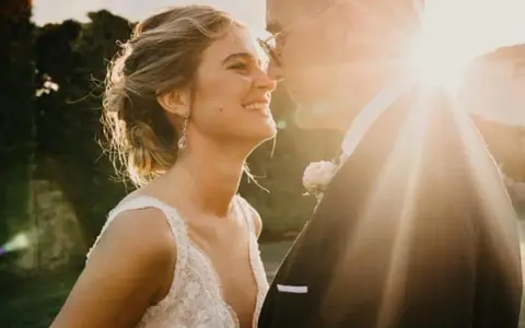Novia sonriente y novio en su boda. La luz del sol ilumina el momento especial de laura escanes boda.