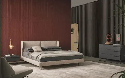 Habitación moderna con pared texturizada en rojo terracota, cama beige y cómoda gris. Inspírate para como pintar una habitacion.