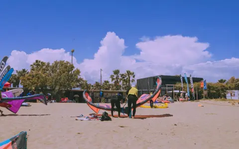 Kitesurfer bereiten sich am Strand von Roses auf den Sport vor.