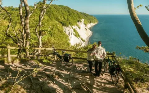 Para zakochanych podziwia widok na klify Møns Klint. Obok stoją rowery, gotowe do dalszej podróży.