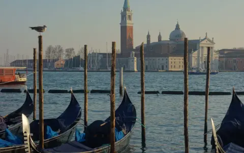 Gondole czekają na turystów na weneckiej trasie. W tle kościół San Giorgio Maggiore.