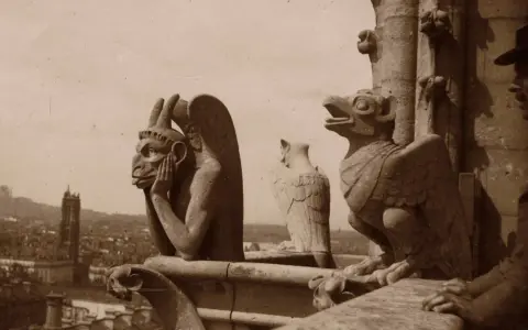 Kamienne gargulce Notre Dame spoglądają na Paryż. Jeden z nich, z rękami przy twarzy, wydaje się zamyślony.