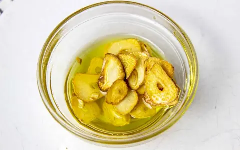 Ajo laminado y dorado en aceite de oliva, listo para añadir sabor a tu rape a la plancha.