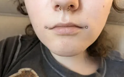 Dahlia piercing zdobi usta, dodając odrobinę buntu.