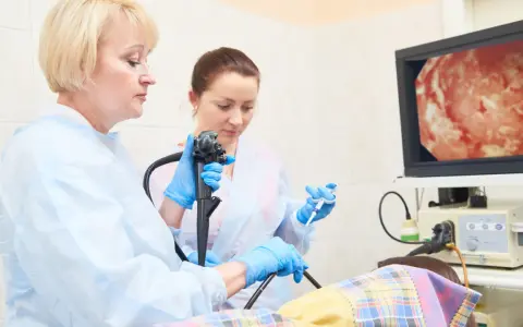 Lekarze wykonują gastroskopię, badanie wnętrza żołądka, obserwując obraz na monitorze.