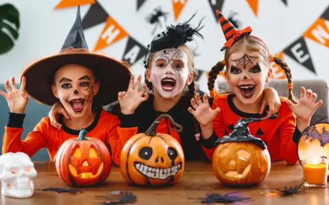 Tre barn med läskig ansiktsmålning och halloweenkostymer njuter av halloween aktiviteter med pumpor och dekorationer.