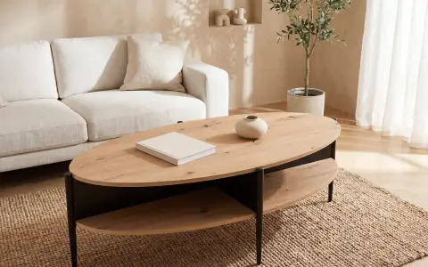 Ett stilrent vardagsrum med en beigefärgad soffa och ett modernt, ovalt soffbord i trä med två hyllplan.