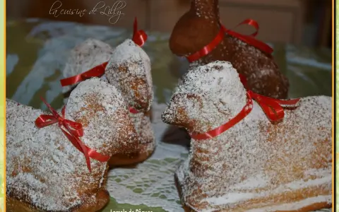 Lamala de Pâques, une recette de grand-mère pour un dessert festif. Ces agneaux en gâteau, saupoudrés de sucre glace et ornés de rubans rouges, évoquent la tradition.