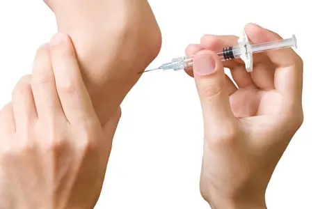 Eine Spritze wird an einem Ellbogen angesetzt. Dies ist ein Schritt in der biologika therapie zur Behandlung von Entzündungen.