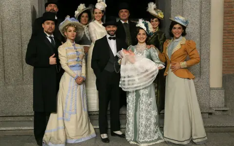Un gruppo di persone in abiti d'epoca, con un neonato in braccio, anticipazioni una vita di famiglia e tradizione.