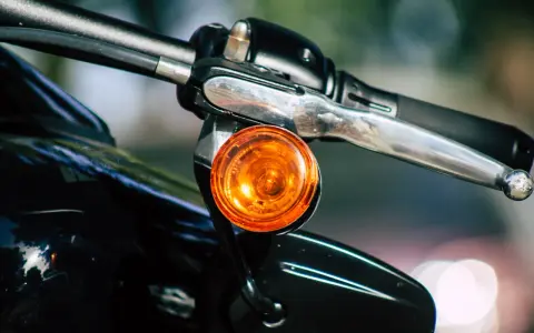 Pomarańczowy kierunkowskaz motocykla, gotowy do sygnalizowania skrętu.