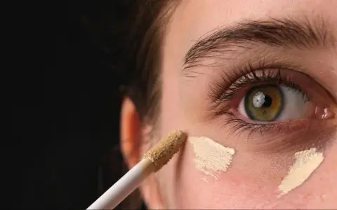 Aplikator korektora nakłada jasny podkład pod okiem.